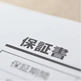 「保証書」と記載された書類の一部が写っており、製品やサービスの保証に関する文書を示している。
