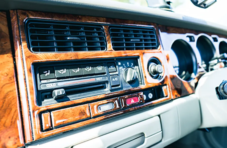車のダッシュボード部分、エアコンのダイヤルとラジオの操作パネルがアップで映る