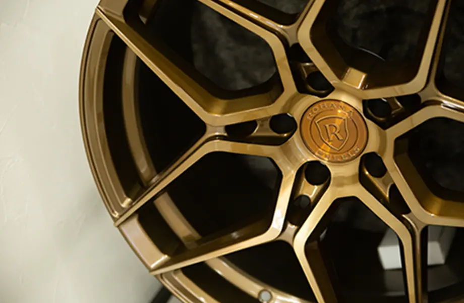 高級車のホイールがクローズアップされた写真、金色の仕上げが目立つ