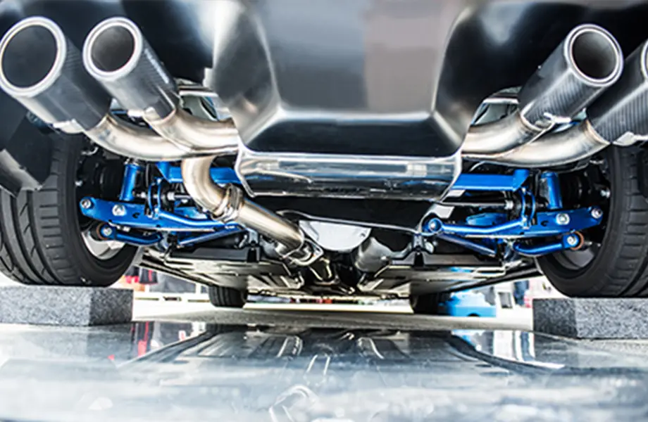 車の下部に取り付けられた排気システムの詳細、クロームメッキのパイプが並ぶ