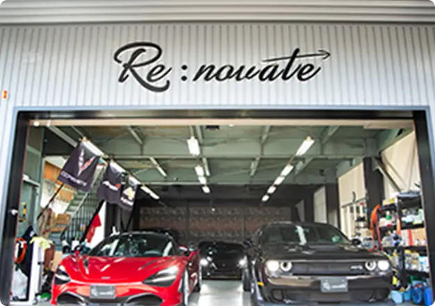 自動車整備工場の正面にRe:novateのロゴと2台のスポーツカーが並ぶ様子