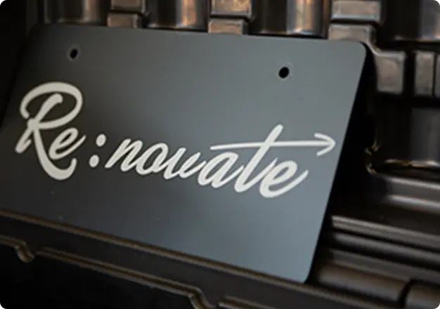Re:novateロゴ入りプレートが黒いボックスの上に置かれたクローズアップ写真