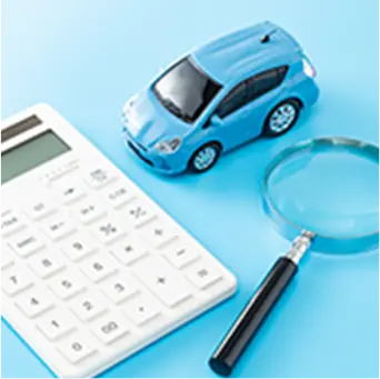 電卓と虫眼鏡、青いミニカーが並べられた、車の査定や保険に関連するイメージ