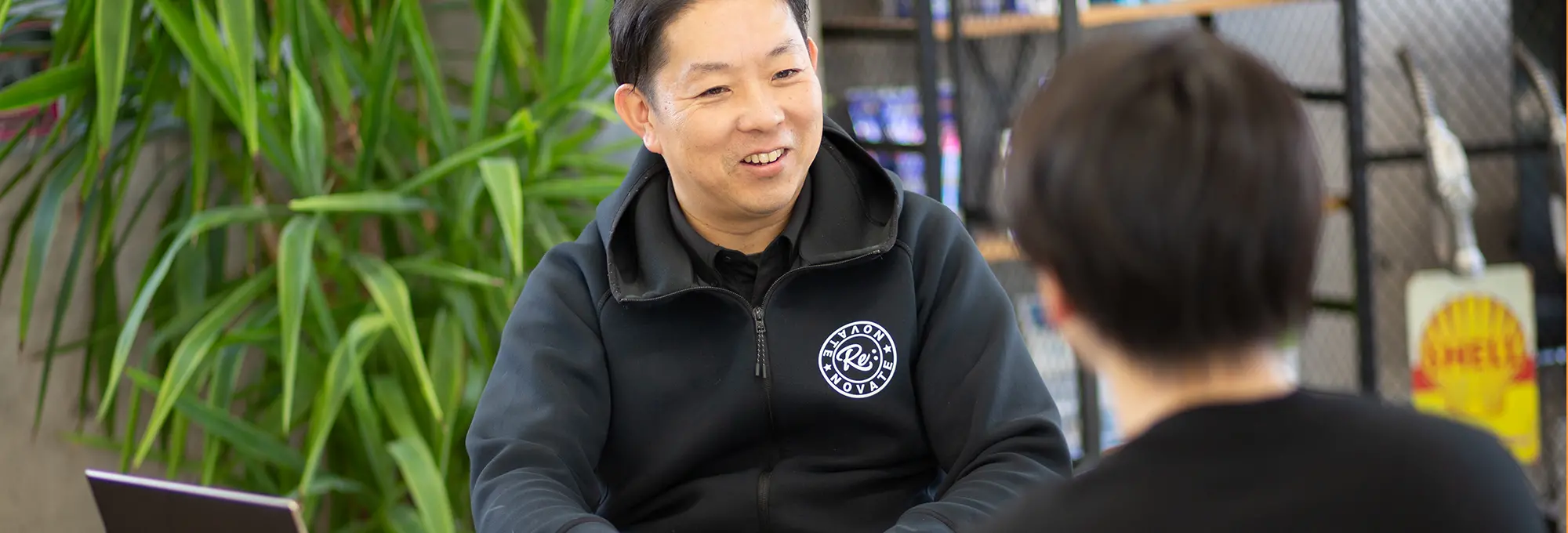 カーディーラーの相談カウンターでの接客風景を示すシーン